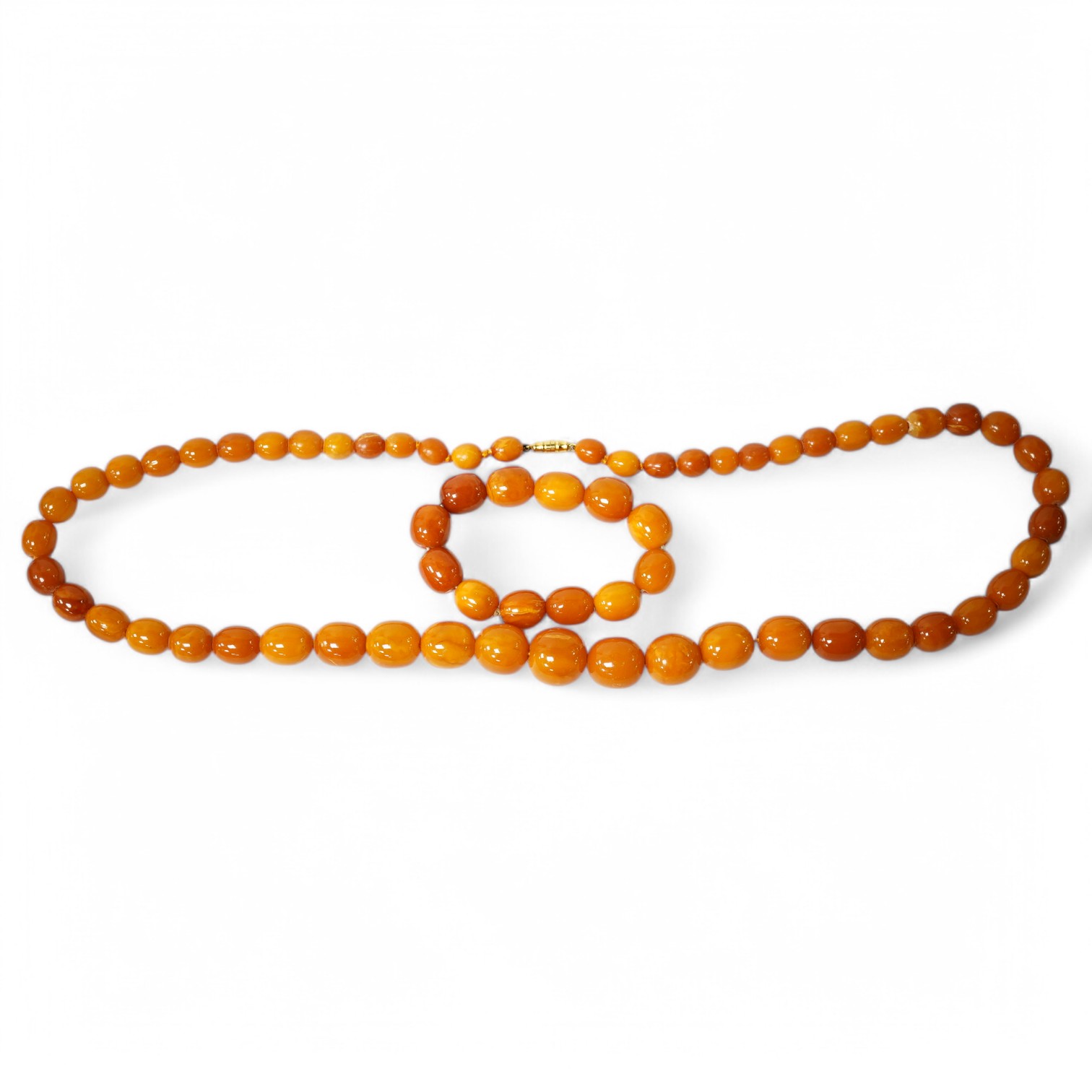 A single strand graduated amber bead necklace, 70cm, gross weight 67 grams, together with an amber bead bracelet, gross weight 20 grams. Condition - poor to fair